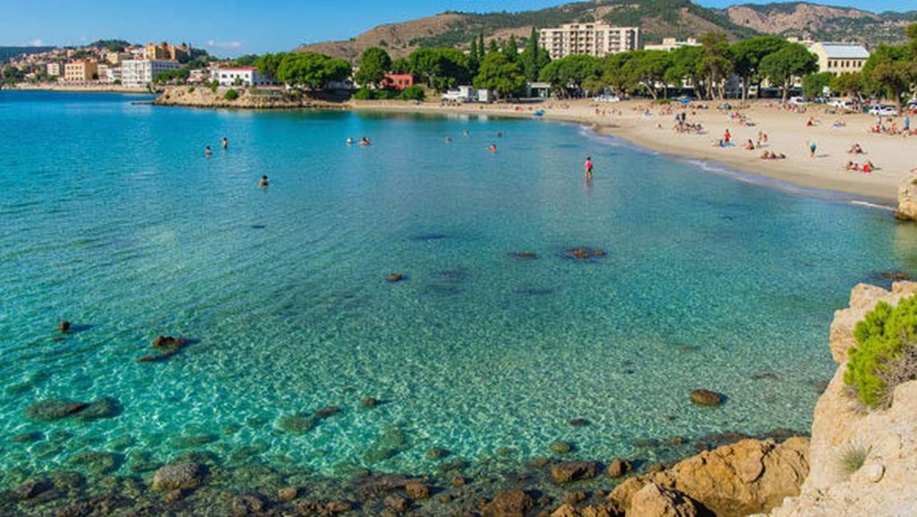 Orilla de caló dels Reis con olas suaves en Calvià
