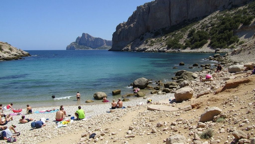 Orilla de Cala Bóquer con olas suaves en Pollença