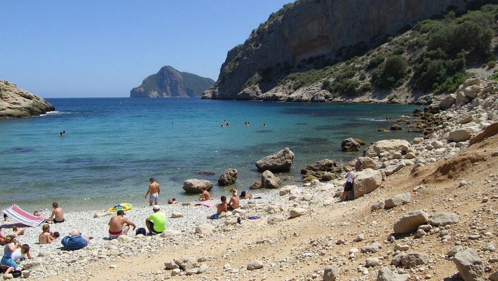 Orilla de Font de Cala Bóquer con olas suaves en Pollença