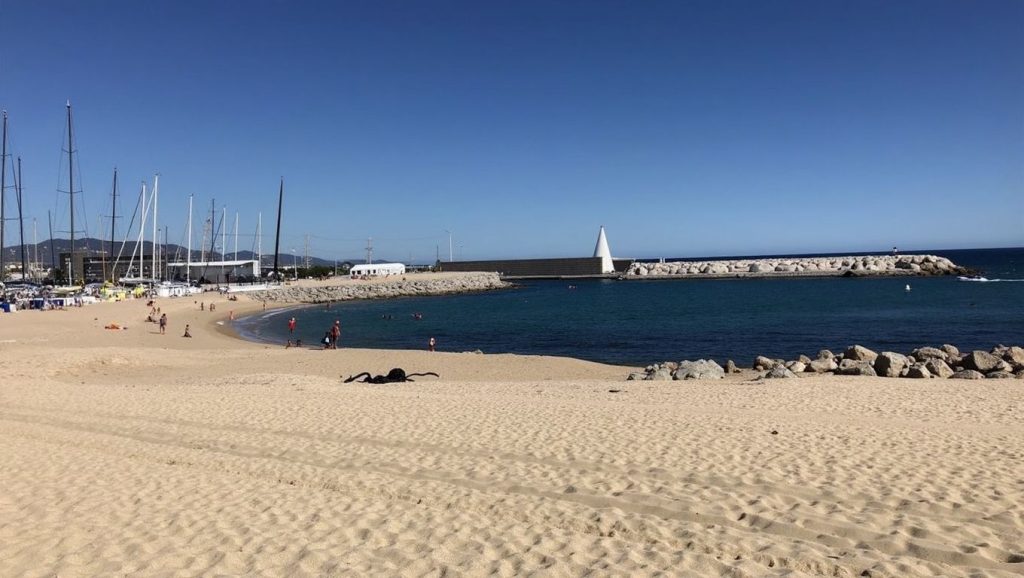 Orilla de Platja d'En Moragues con olas suaves en Badalona