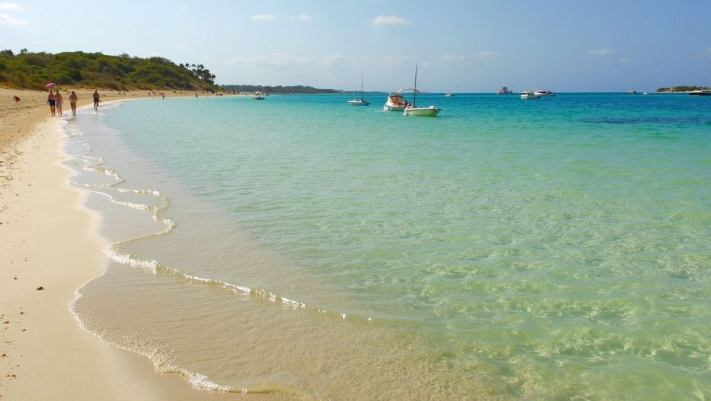 Orilla de Platja d'es Port con olas suaves en Ses Salines