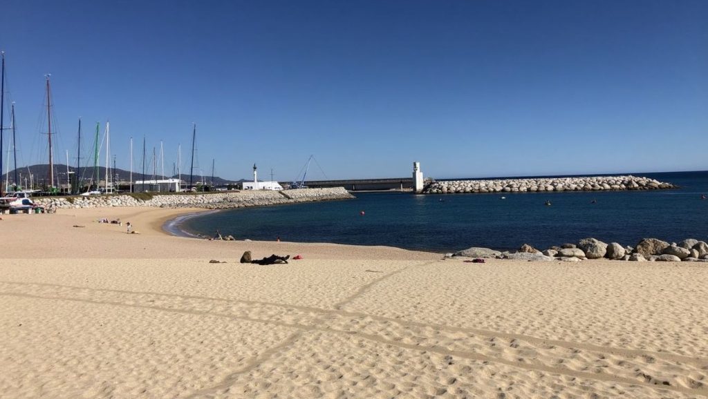 Orilla de Platja del Progrés con olas suaves en Badalona