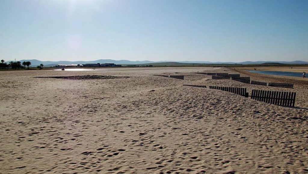 Orilla de Playa Los Bateles con olas suaves en Conil de la Frontera