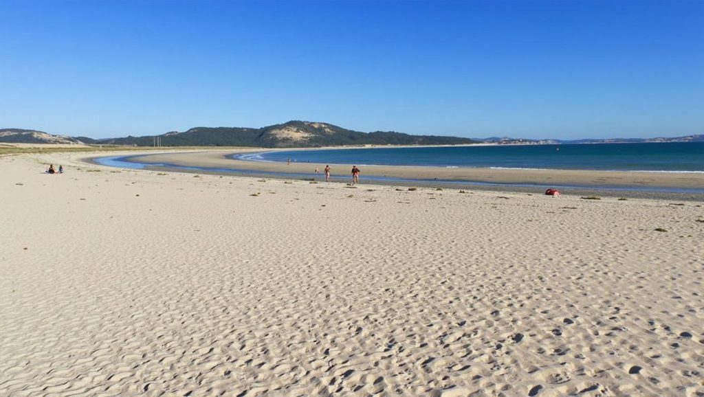 Orilla de Praia da Romera con olas suaves en Galicia