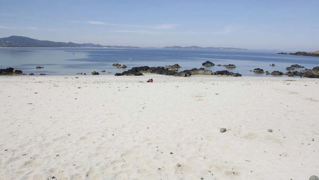 Detalle de arena y agua en Praia do Prado, Galicia