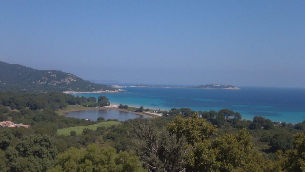 Arena y orilla en Plage Le Rocher, Calvi, Córcega