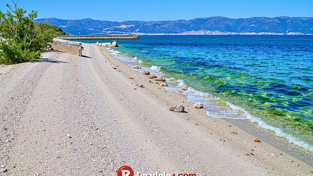 Detalle de arena y agua en Plaža Lumbrelin, Croacia