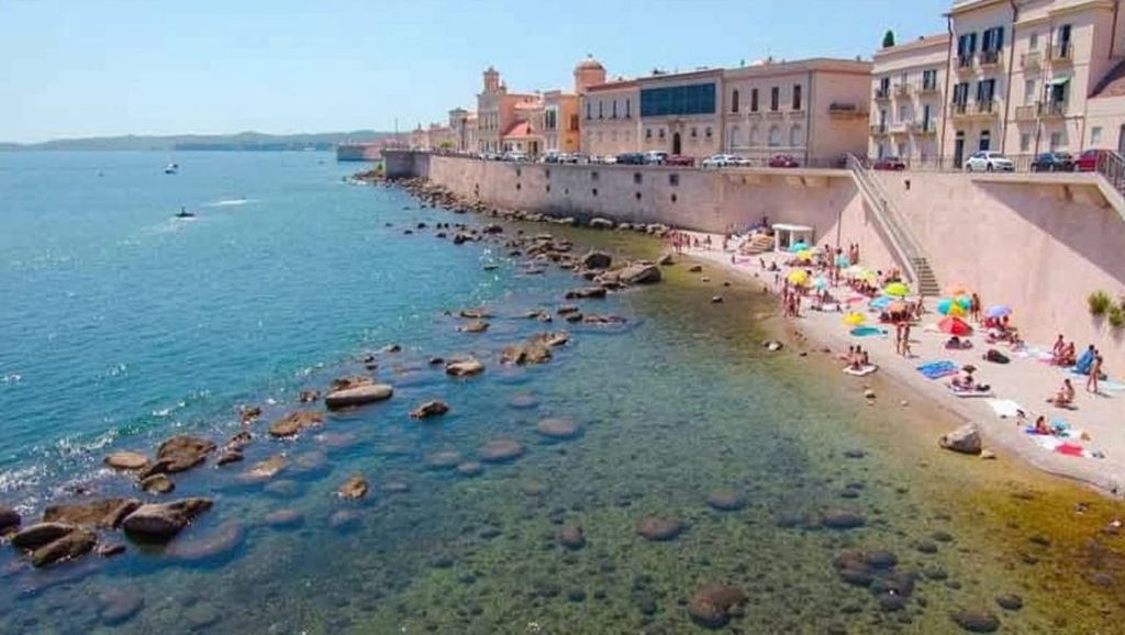 Orilla de Spiaggetta di Cala Rossa con olas suaves en Siracusa